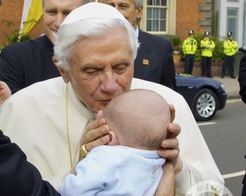 Pope Benedict kisses a baby.