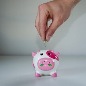 Someone saving money in a piggy bank