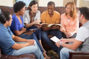 Diverse group of adults sitting together with Bibles and notebooks during fun bible games for adults