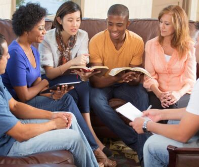 Diverse group of adults sitting together with Bibles and notebooks during fun bible games for adults