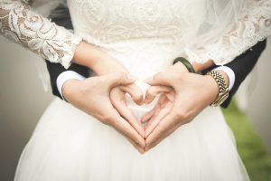 Husband and wife forming a heart sign with their hands