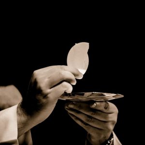 A Catholic priest raising the blessed Eucharist during mass.