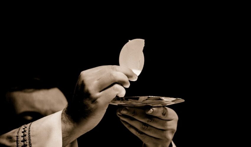 A Catholic priest raising the blessed Eucharist during mass.