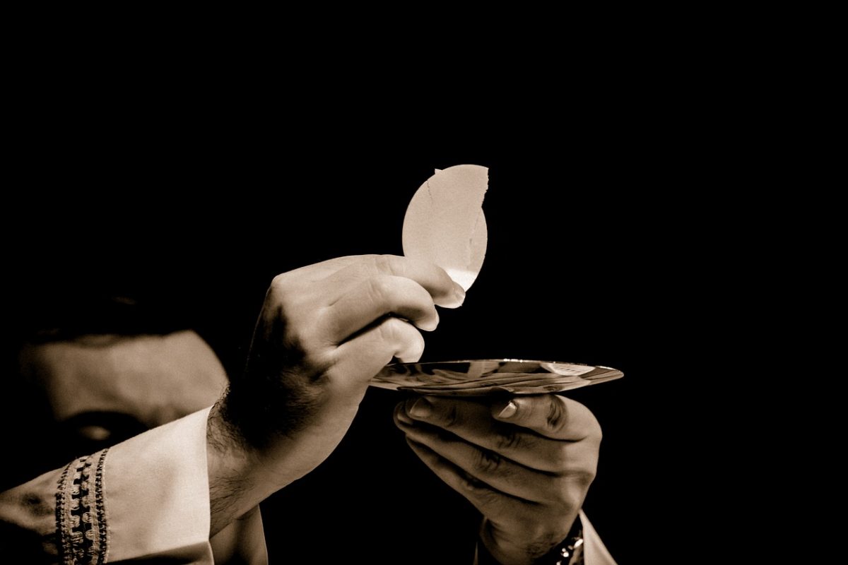 A Catholic priest raising the blessed Eucharist during mass.