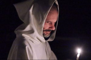 A monk carrying a candle.