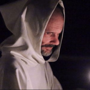 A monk carrying a candle.