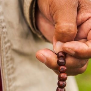 A person praying the rosary. Monastic practices for everyone.