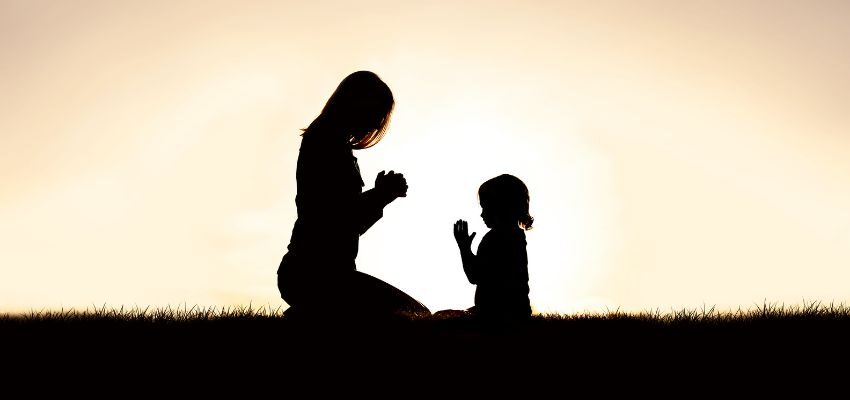 A mother facing her daughter while praying together indicates that she is a spiritual mother.