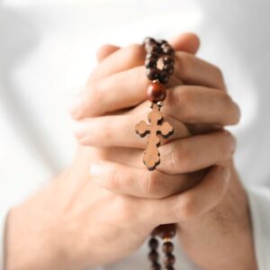 A Catholic praying the rosary in Latin.