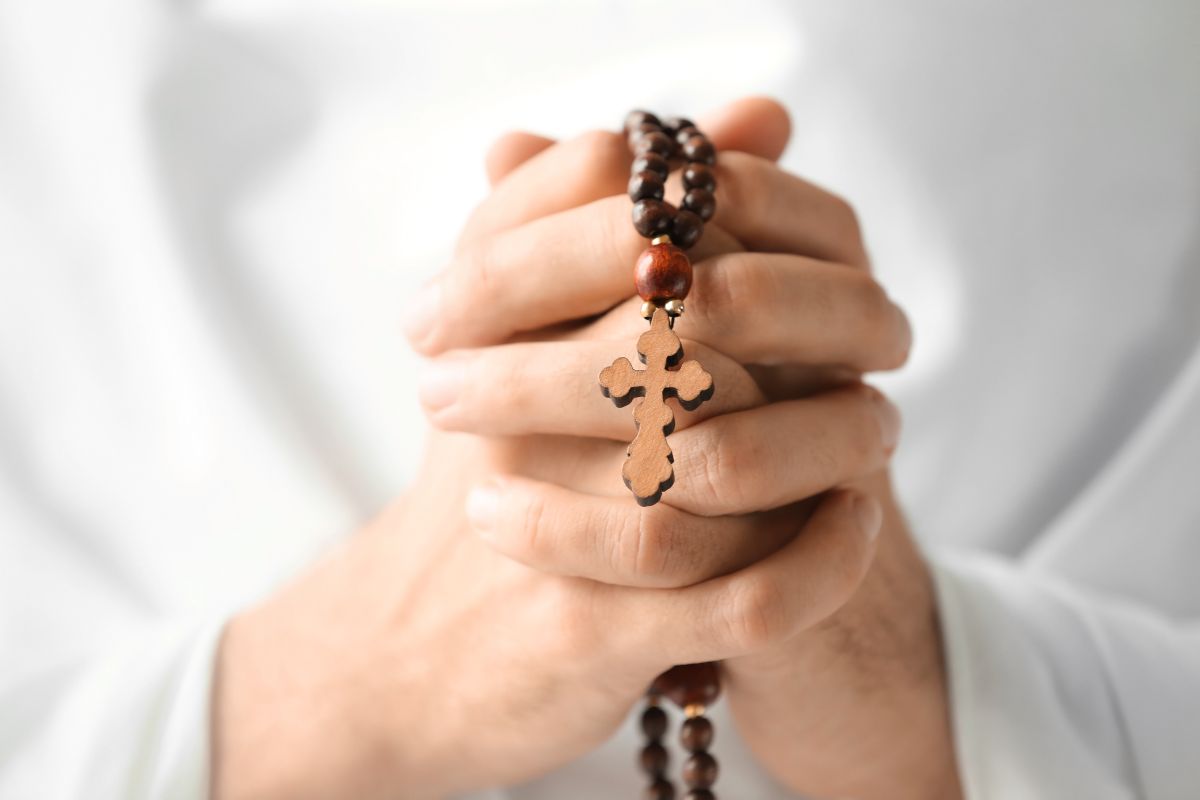 A Catholic praying the rosary in Latin.