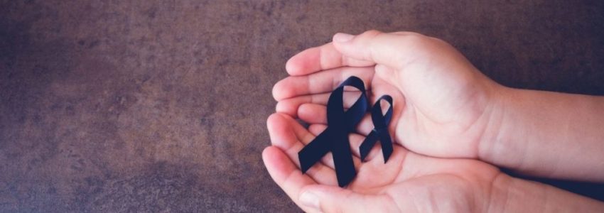 A person is holding a black ribbon representing death.