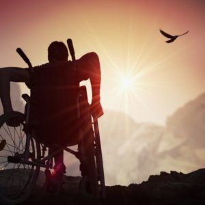 Disabled man staring at the sky during the sun set