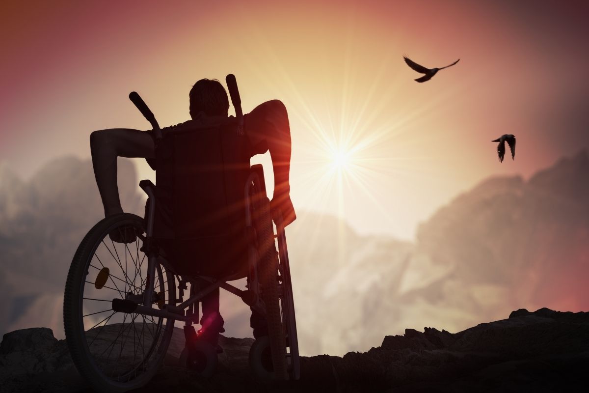 Disabled man staring at the sky during the sun set