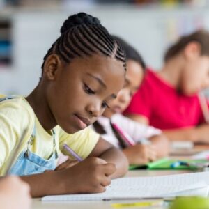 A school aged child studying in class.