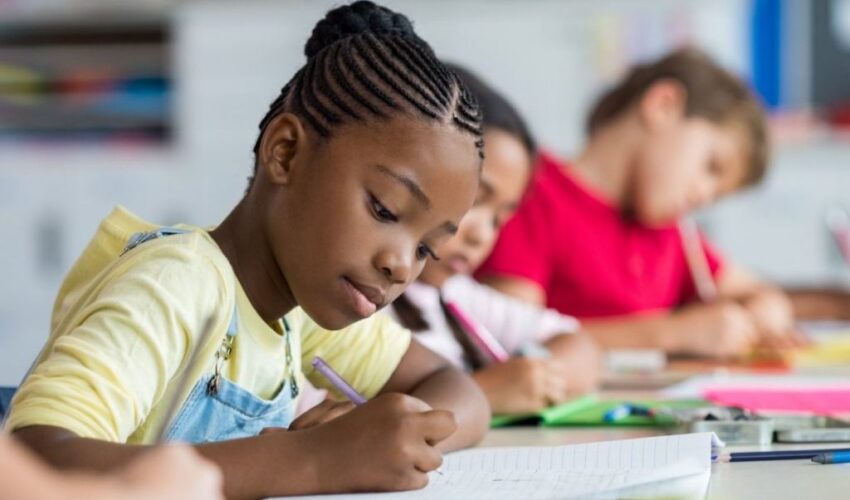 A school aged child studying in class.