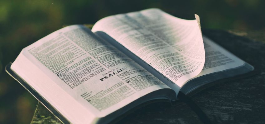 Bible opened to the Book of Psalms resting on a wooden table, highlighting popular psalm verses in the Bible.