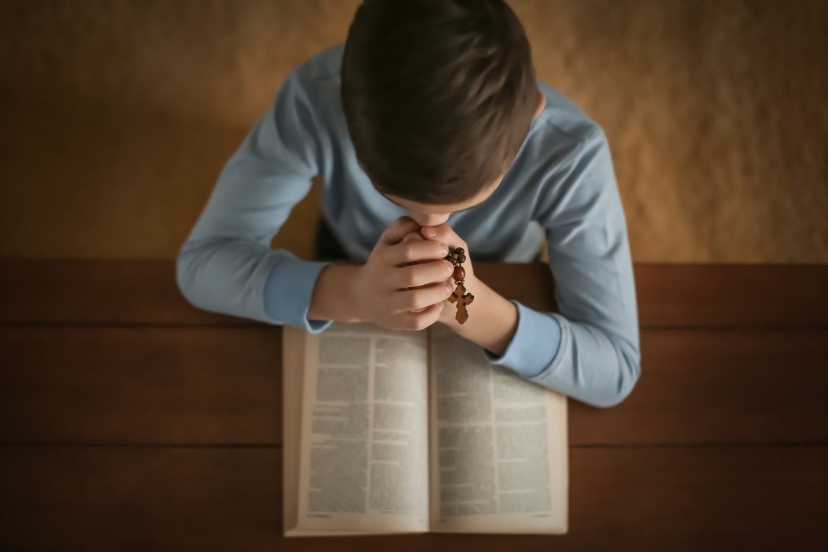 A Catholic child reading Bible verses for kids.