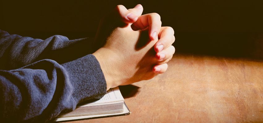 The woman prays after reading a Bible verse about waiting for love.