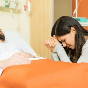 A woman praying for her husband's healing.