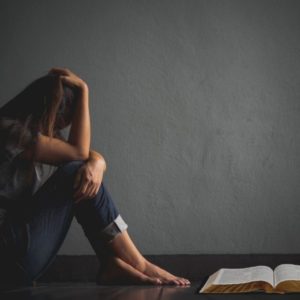 A woman looking at bible verses for the weary.