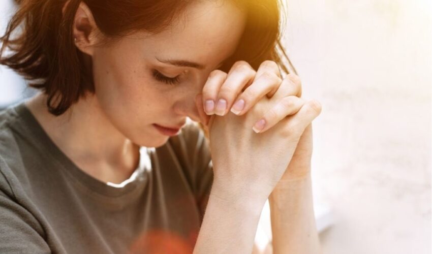 A man kneeling in front of the cross as a sign of repentance for the mortal sins he has committed.