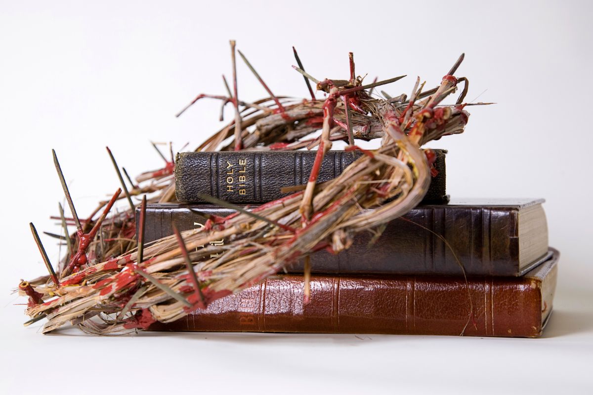 A crown of thorns sitting atop a pile of bibles.