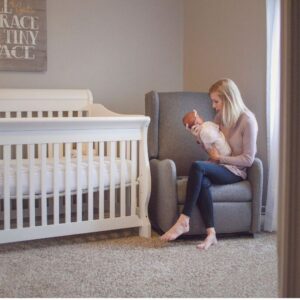 A mother cuddling her child while sitting inside the nursery.