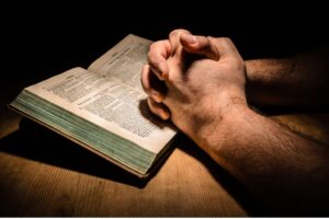 A man reads bible verses about the power of prayer.