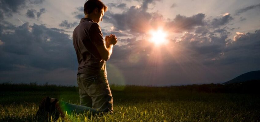 A man knelt on the grass to pray for a miracle to God.