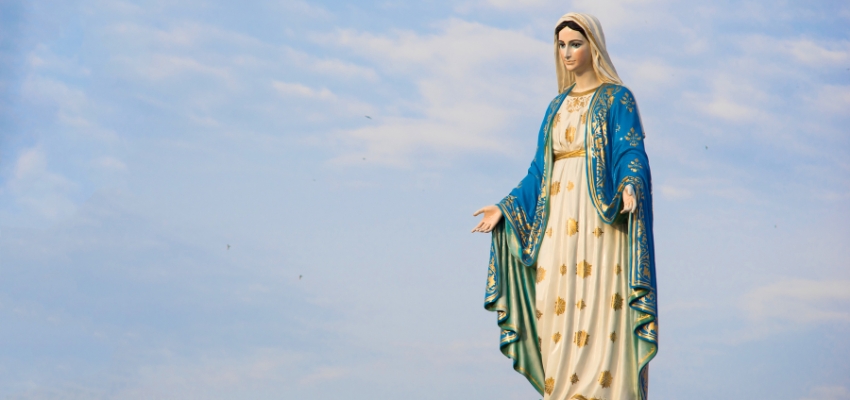 Statue of the Blessed Mother standing gracefully against a blue sky, a common devotional image associated with prayers to the blessed mother.