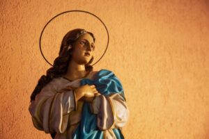 Close-up of a serene statue of the Blessed Mother with hands clasped in prayer, evoking deep devotion and prayers to the blessed mother.