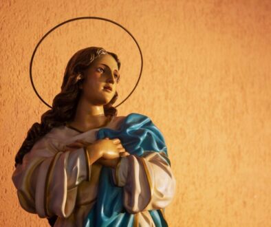 Close-up of a serene statue of the Blessed Mother with hands clasped in prayer, evoking deep devotion and prayers to the blessed mother.