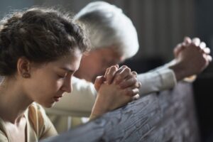 A woman prays after she reads scriptures about a virtuous woman.