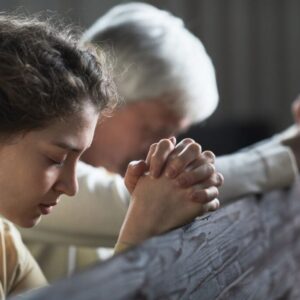 A woman prays after she reads scriptures about a virtuous woman.