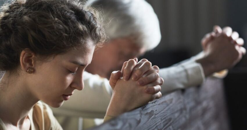 A woman prays after she reads scriptures about a virtuous woman.