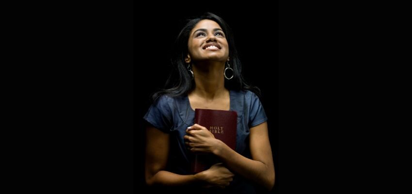 The lady is happy after she finds in the bible where you find the Song of Solomon verses.