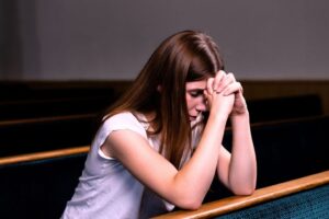 The woman is praying a short prayer.