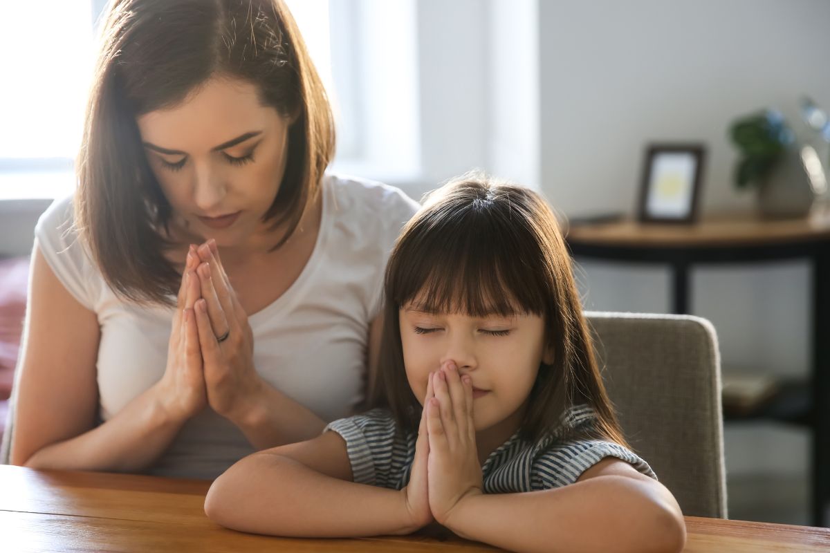 A mother and daughter are praying for healthy body.