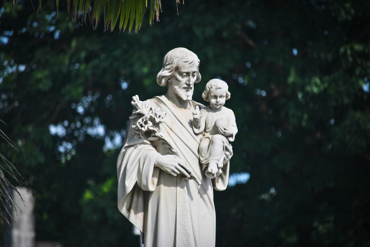 A statue of a saint of protection holding a child, symbolizing faith, safety, and divine guardianship.