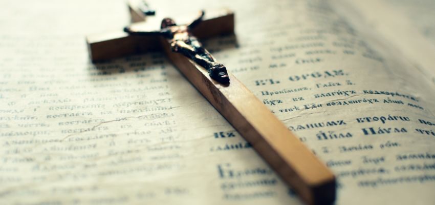 catholic prayers protection (1) A wooden cross rests on the Bible.