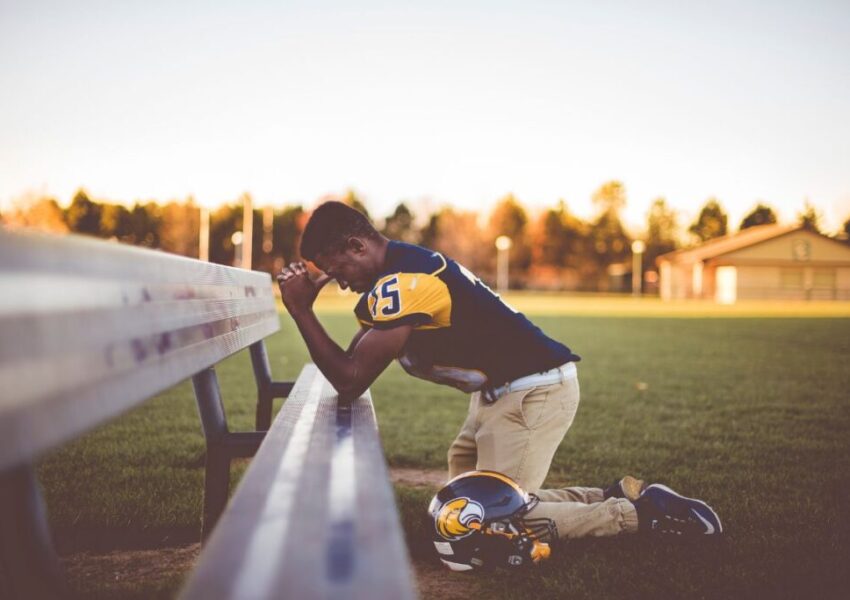 The athlete prays before the start of the game.