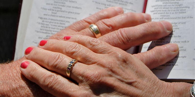 Hands of husband and wife together in prayer