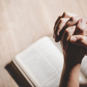 The person is praying to St. Lucy after reading a bible.