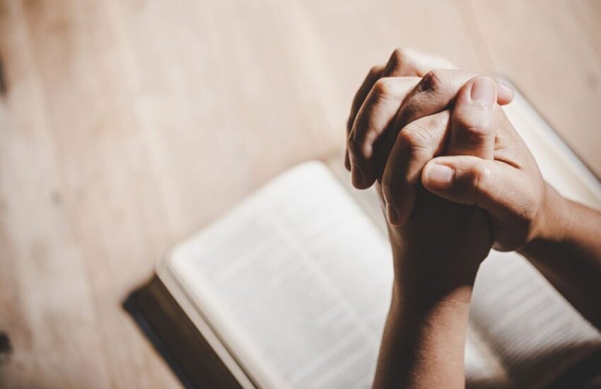 The person is praying to St. Lucy after reading a bible.