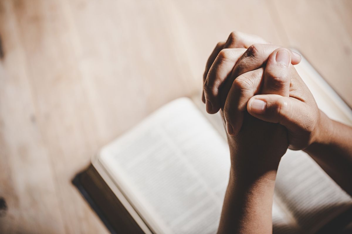 The person is praying to St. Lucy after reading a bible.