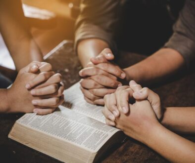 The group of people pray together after reading bible verses.