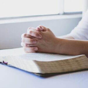 The woman is praying after reading bible verses.