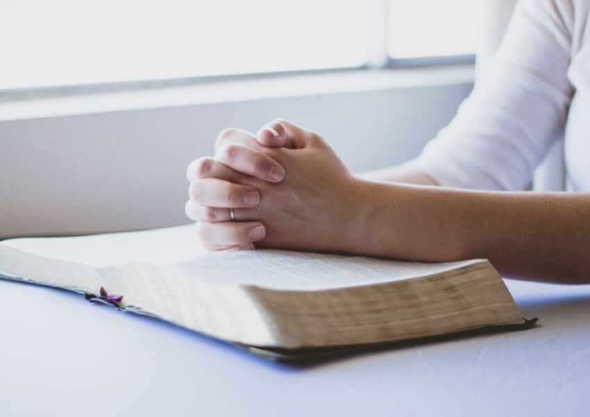 The woman is praying after reading bible verses.