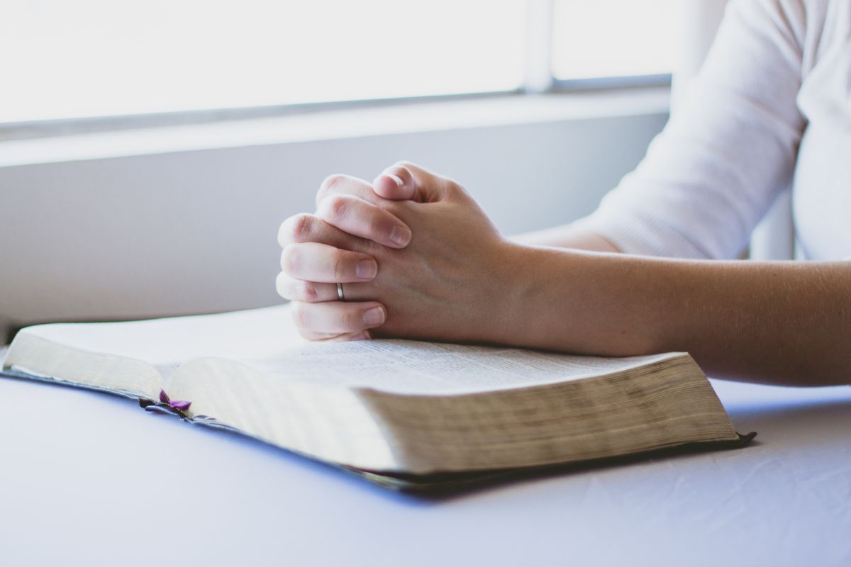 The woman is praying after reading bible verses.