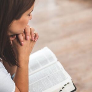 The woman solemnly prays every morning.